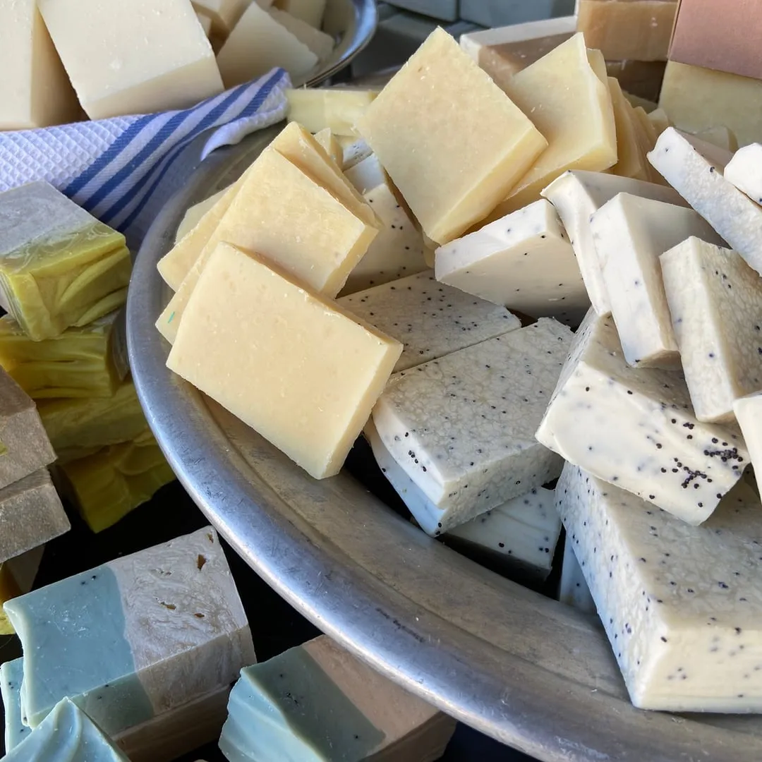 Cremefarbene Naturseifen mit Kräutern in einer Schale